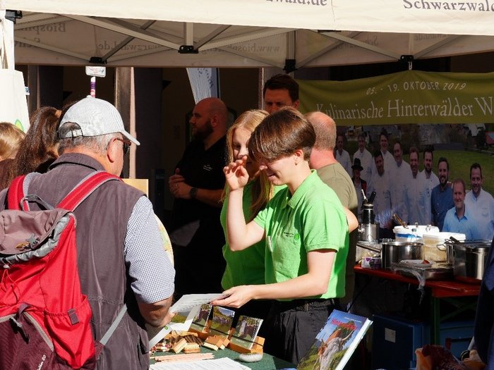 Chistina steht am Infostand des Biosphärengebietes und spricht mit Besucher*innen