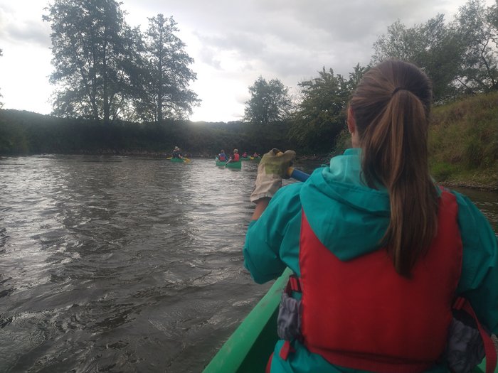 Eine Person ist von hinten zu sehen, in einem Kanu auf der Blies