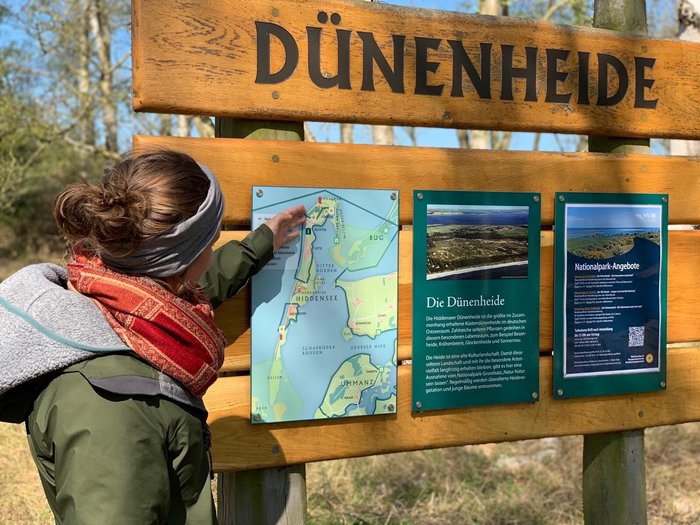 Anna-Lena Schweizer zeigt auf eine Karte der Insel Hiddensee.