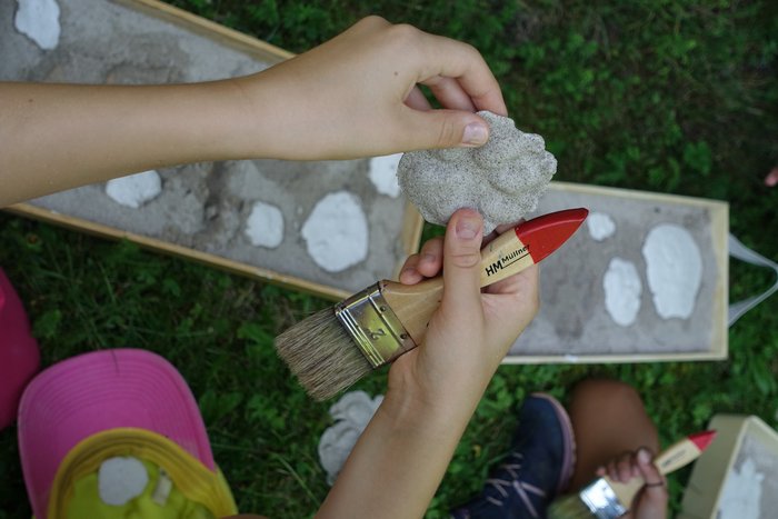 Ein Kind hält den Abdruck einer Tierpfote in der Hand