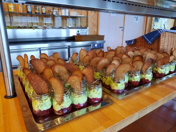 Buffet mit in Gläschen gefüllten Essen.