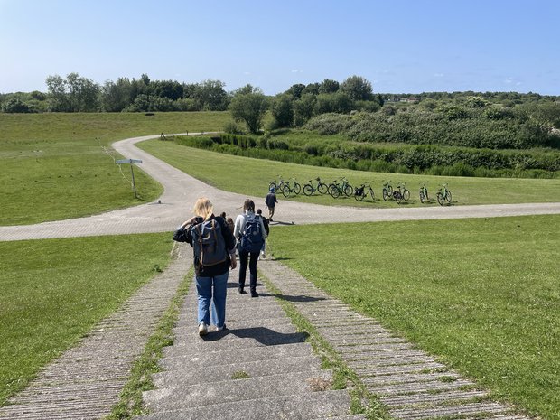 Foto: Jan-Malte Paatz Mehrere Personen laufen eine in einer Wiese gelegenen Treppe herunter, im Hintergrund stehen Fahrräder