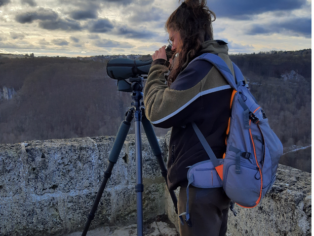 Emma beobachtet durch ein Spektiv Vögel
