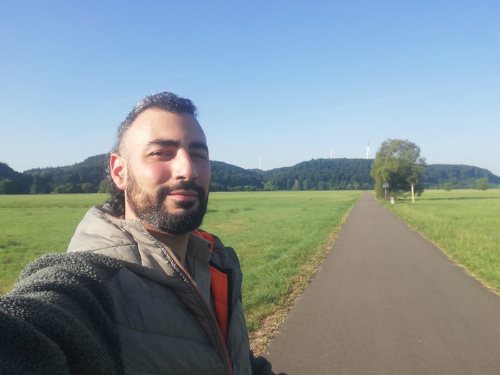 Wito mit Wiese und Hügeln im Hintergrund