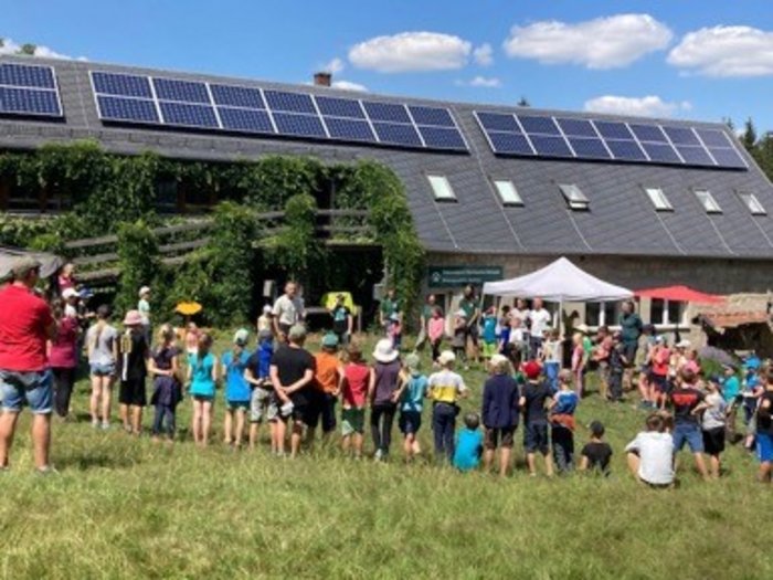 Eine Gruppe Schulkinder steht in einem Abschlusskreis des Junior-Ranger-Treffen 2022.                                                                                           